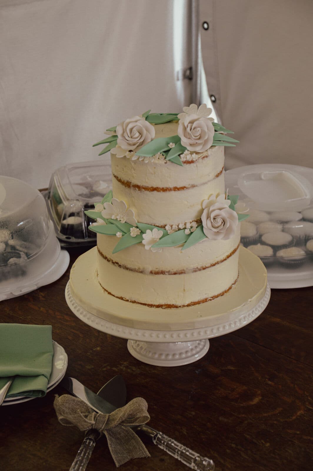 Tiered wedding cake with rose details under the tent